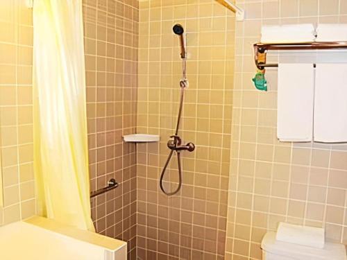 een badkamer met een douche met een douchegordijn bij Jinjiang Inn Yueyang Railway Station in Yueyang