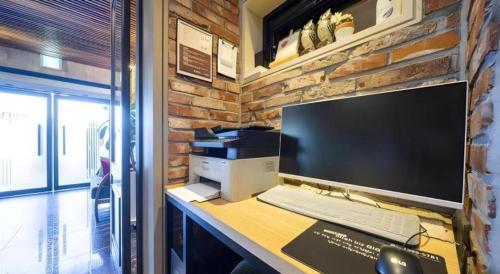 a desk with a computer monitor and a keyboard at Pohang Hotel View in Pohang