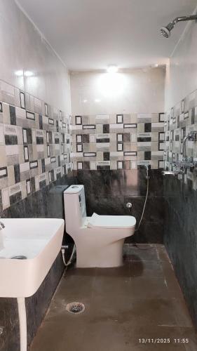 a bathroom with a white toilet and a sink at Nilaya in Varanasi