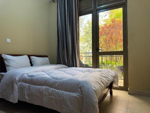 a bedroom with a bed and a large window at Dafrican BnB villa in Kigali