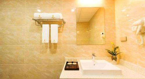 un baño con lavabo y espejo en Kim Bao Hotel, en Hải Dương