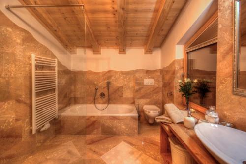 ein Badezimmer mit einer Badewanne, einem WC und einem Waschbecken in der Unterkunft Logenplatz Zillertal in Ramsau im Zillertal
