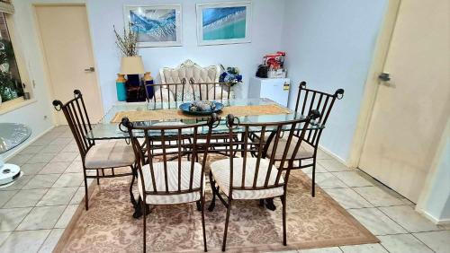 a dining room with a glass table and chairs at Hills Bed & Breakfast in Pennant Hills