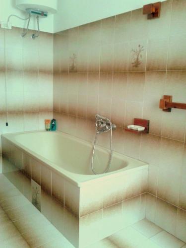 a bathroom with a tub with a shower in it at Mare&Monti Guest House with Private Parking in Telti