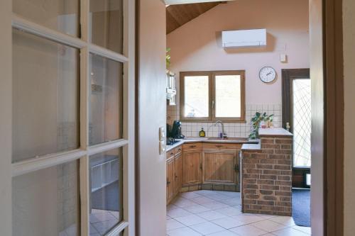 een keuken met houten kasten, een wastafel en een raam bij Nature et Calme Entre Deux Lacs in La Biolle