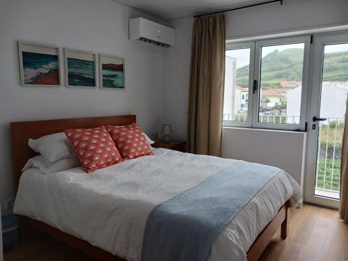 una camera da letto con un letto con due cuscini sopra di Lagoa Princess Condo a Lagoa