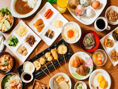 大阪APA Hotel Shin Osaka Minamikata Ekimae的桌子上摆着许多盘子食物