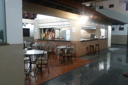 uma área de refeições com mesas e cadeiras num restaurante em Barrocos Hotel em Rondonópolis