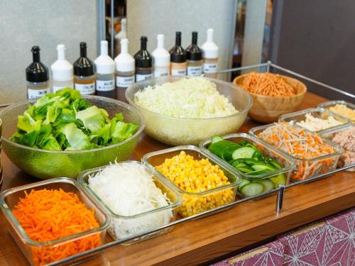 大阪APA Hotel Shin Osaka Minamikata Ekimae的桌子上放着蔬菜和其他食物的托盘