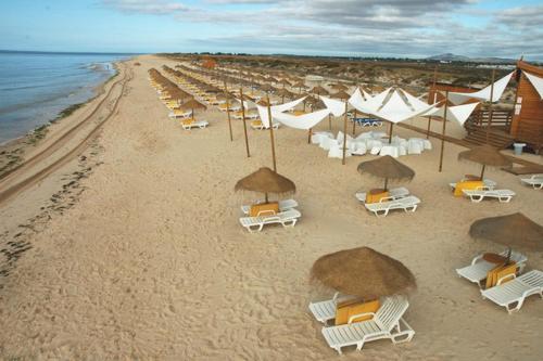an overhead view of a beach with chairs and umbrellas at Flamingo Beach House in Santa Luzia