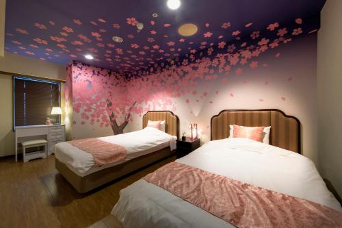 a bedroom with two beds and a purple wall with hearts at Maholova Minds Miura in Miura