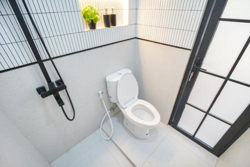 ein Badezimmer mit einer weißen Toilette in einer Kabine in der Unterkunft Oemah Rotan Homestay Jogja in Yogyakarta