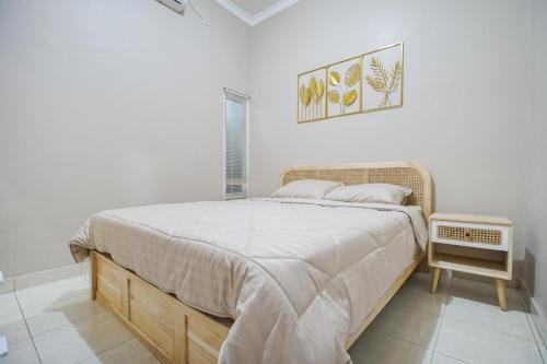 ein Schlafzimmer mit einem großen Bett in einem weißen Raum in der Unterkunft Oemah Rotan Homestay Jogja in Yogyakarta