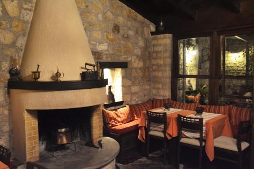 a fireplace in a restaurant with two tables and a couch at Hagiati Guesthouse in Ioannina