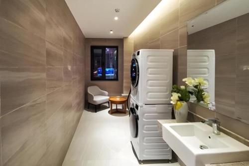 a bathroom with a sink and a refrigerator at Yitel Collection Shenyang North Railway Station Metro Station in Shenyang