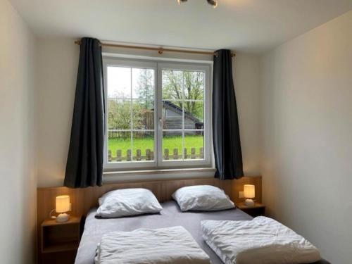 een slaapkamer met twee bedden en een groot raam bij Apartment in Katschberg near Ski Slopes in Sankt Margarethen im Lungau