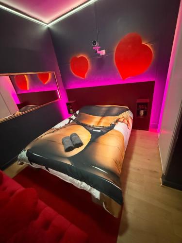 a bedroom with a bed with hearts on the wall at Love&spa in Valras-Plage