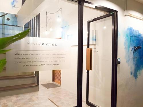 アオナンビーチにあるMini Boxtel Aonang Hostelの壁面の看板付きガラス戸
