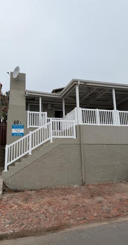 un edificio con una barandilla blanca y una escalera en Point View Selfcatering, en Mossel Bay