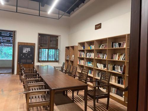 una biblioteca con una mesa larga, sillas y estanterías en Leela, en Green Island
