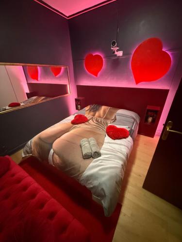 a bedroom with a bed with hearts on the wall at Love&spa in Valras-Plage
