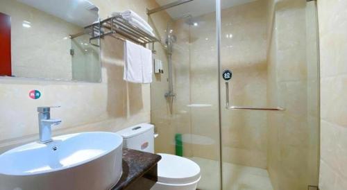 a bathroom with a toilet and a sink and a shower at GreenTree Inn HanZhong Railway Station Beiyihuan Road Express Hotel in Shima