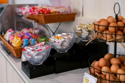 a buffet filled with eggs and baskets of food at One Budget Hotel Chiangrai Maesai Payang in Ban Pa Yang