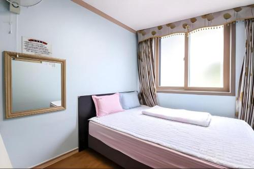 a small bedroom with a bed and a mirror at Ace Hotel in To-dong