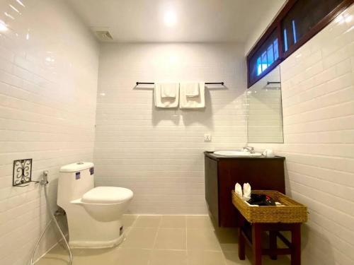 een witte badkamer met een toilet en een wastafel bij Paradise K Forest Hotel in Siem Reap