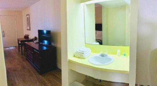 un baño con lavabo y espejo en Niagara Best Inn, en Niagara Falls