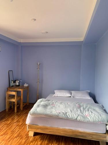 a bedroom with a bed with a blue wall at DIPSAGAR Hotel And Lodge in Bandīpur