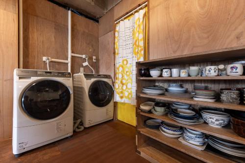 a laundry room with two washing machines and plates at Kanazawa 旅音 in Kanazawa