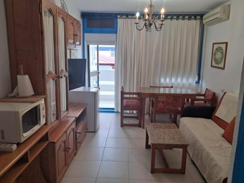 a living room with a couch and a microwave at Apartamento 236 Flamesol in Matalascañas