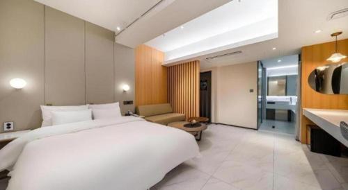 een slaapkamer met een groot wit bed en een woonkamer bij Jongro HOTEL LABOUM in Seoul
