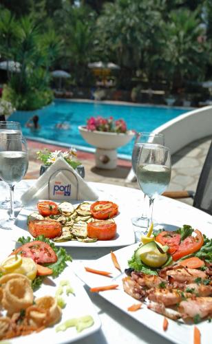a table with two plates of food and glasses of wine at Porfi Beach Hotel in Nikiti