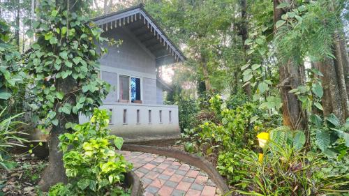 a walkway leading to a house in a garden at Finca Backwater Homestay in Suntikoppa