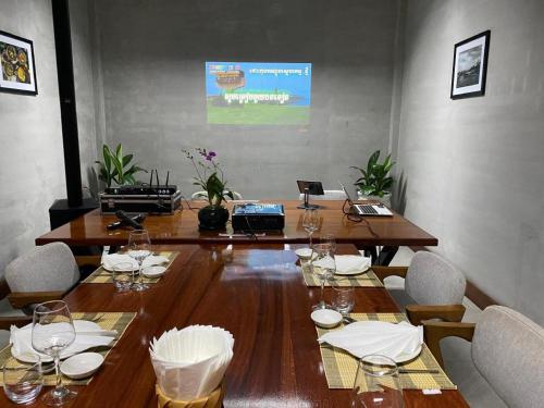 a large wooden table with wine glasses on it at Asian Koh Kong Hotel in Koh Kong