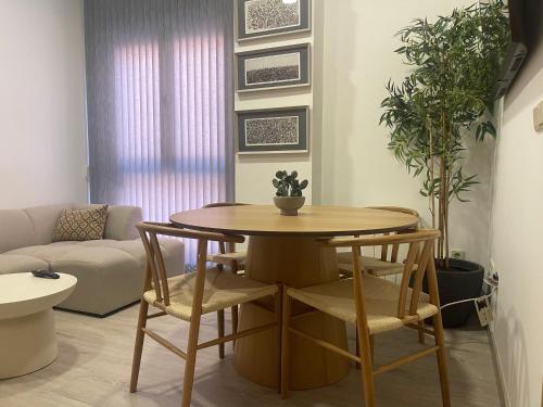 ein Wohnzimmer mit einem Holztisch und Stühlen in der Unterkunft Encanto cuenca puerta al silencio in Cuenca