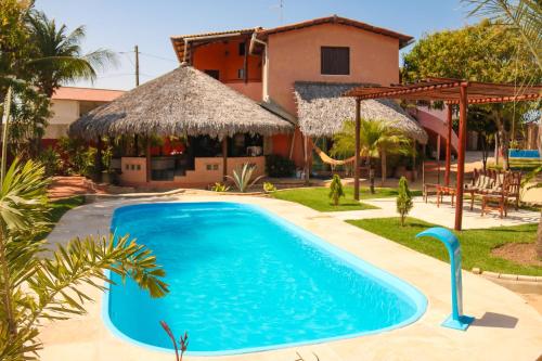 a large blue swimming pool in front of a house at Pousada Villa Botânica in Aracati