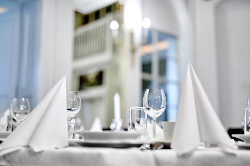 a table with wine glasses and white napkins on it at Pałac Bażantarnia in Pszczyna