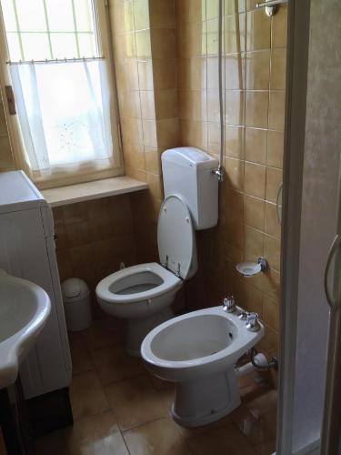 łazienka z toaletą, umywalką i oknem w obiekcie La Tana Del Lupo w mieście Entracque