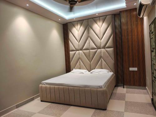 a bedroom with a bed with a padded wall at Hotel O THE ERA INFINITY HOTEL in Faithfulganj
