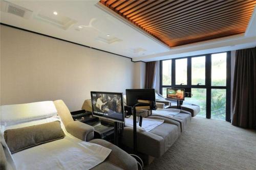 een woonkamer met banken en een tv in een kamer bij HELSTON HOTEL in Guancun