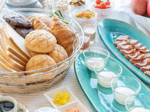 un tavolo con un cesto di pane e piatti di cibo di GLOBAL RESORT NUKUI a Akiota
