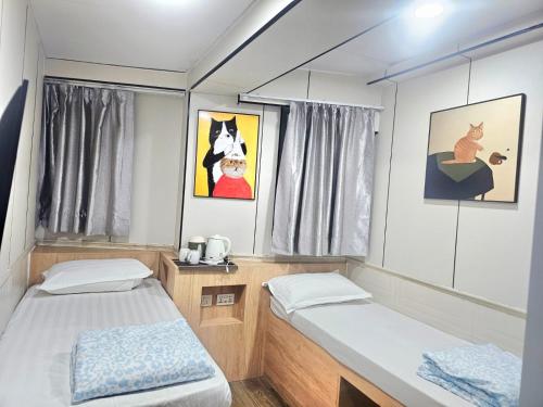 a small bedroom with two beds and a window at K & B Hostel in Hong Kong