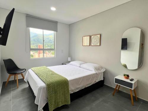 a bedroom with a bed and a chair and a window at Apartamento Familiar en Sabaneta cerca al parque in Sabaneta