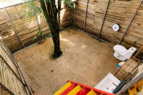 a bathroom with a toilet and a tree in it at Danny Glamping Farm in Bao Loc