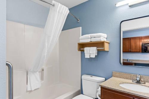 een badkamer met een wastafel, een toilet en een spiegel bij Suburban Studios Clarksville-Louisville North in Clarksville