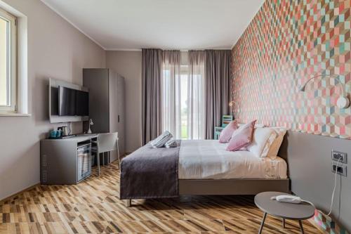 une chambre d'hôtel avec un lit et une télévision dans l'établissement L'aja della Mirusina - Piedmont Resort Monferrato Langhe, à Canelli