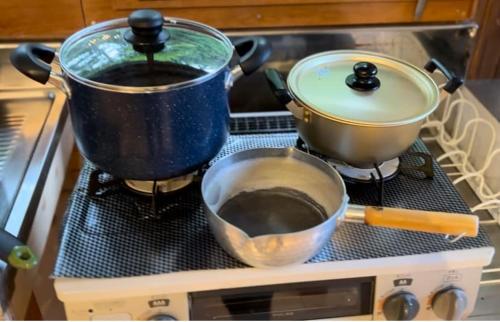 two pots and pans sitting on top of a stove at つなぎ in Nishiwaga